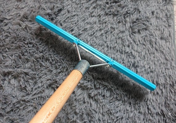 Grandi Groom rake on carpet to remove dog hair. 