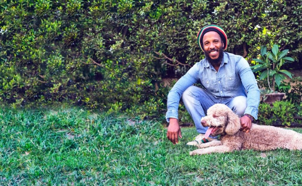 Ziggy Marley and his dog outside.
